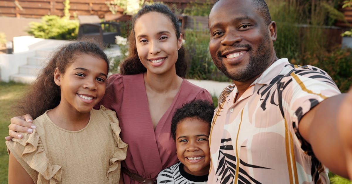 Smiling multicultural family enjoying time together outdoors in their garden.